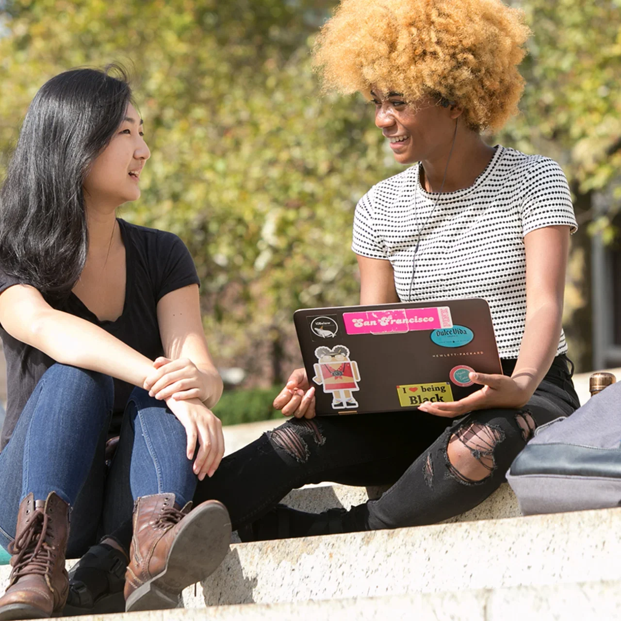 Two students smiling on campus.