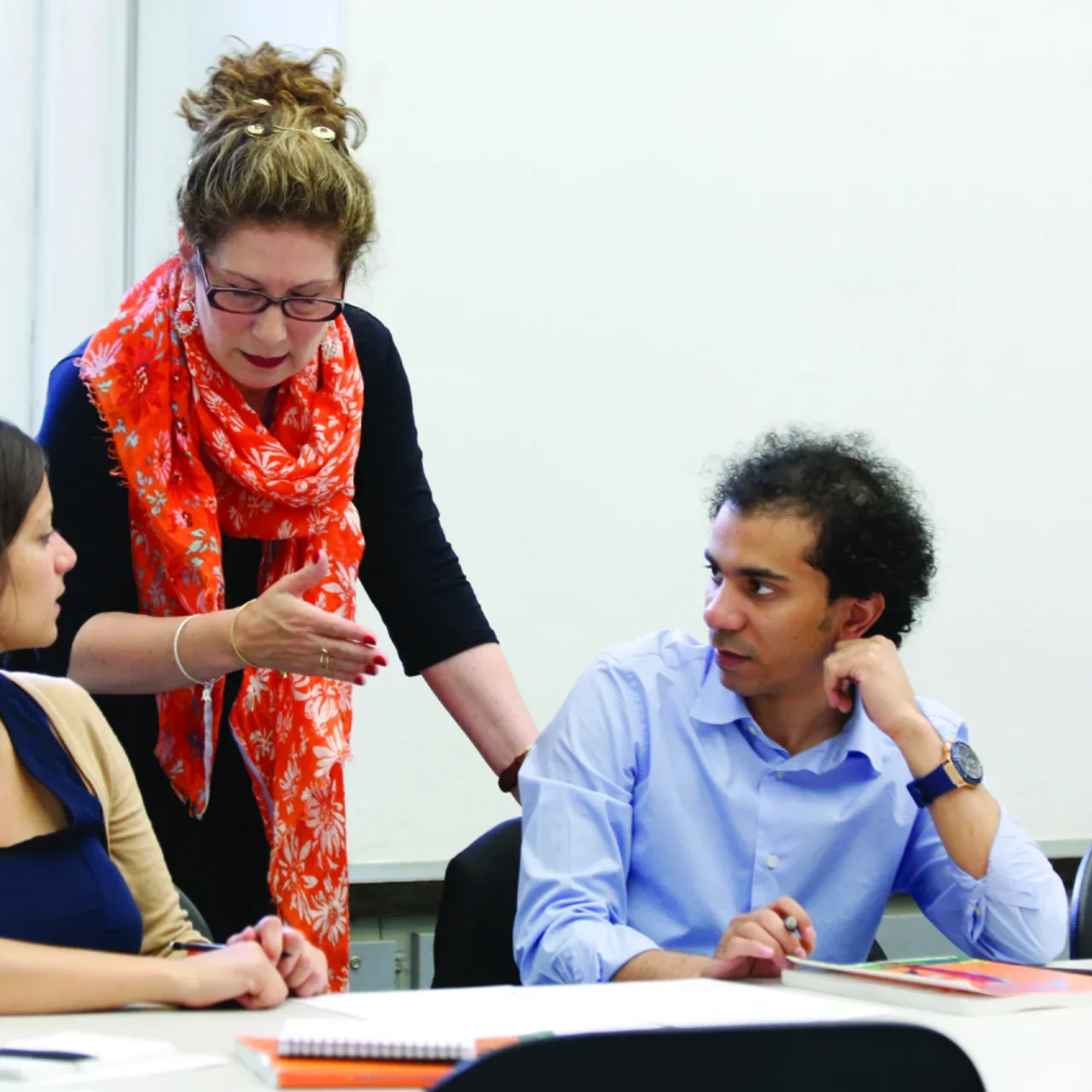 Teacher interacting with two students in class