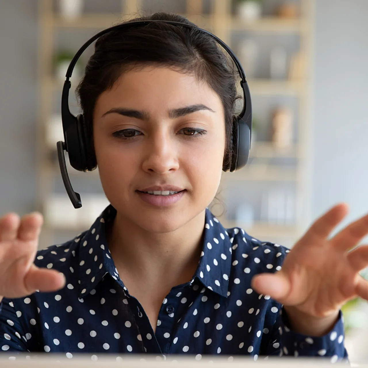 A student with headphones gestures.