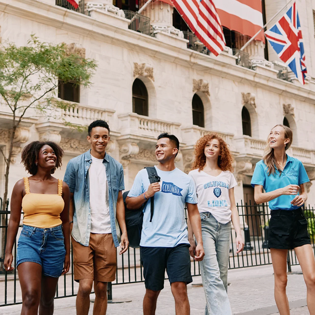Five students walk together in front of New York Stock Exchange.
