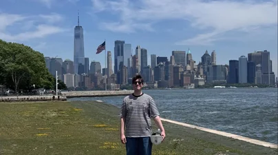 A picture of the New York City skyline and me at Ellis Island, taken after the Hard Hat Tour. The views from Ellis Island were truly spectacular.